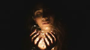 Moody Intimate Portrait with Glowing Fairy Lights , moody portrait, intimate portrait photography, fairy lights portrait, dark background portrait, glowing lights photography, dreamy portrait, mysterious female portrait, low key lighting, cozy aesthetic photography, melancholic mood portrait, warm light